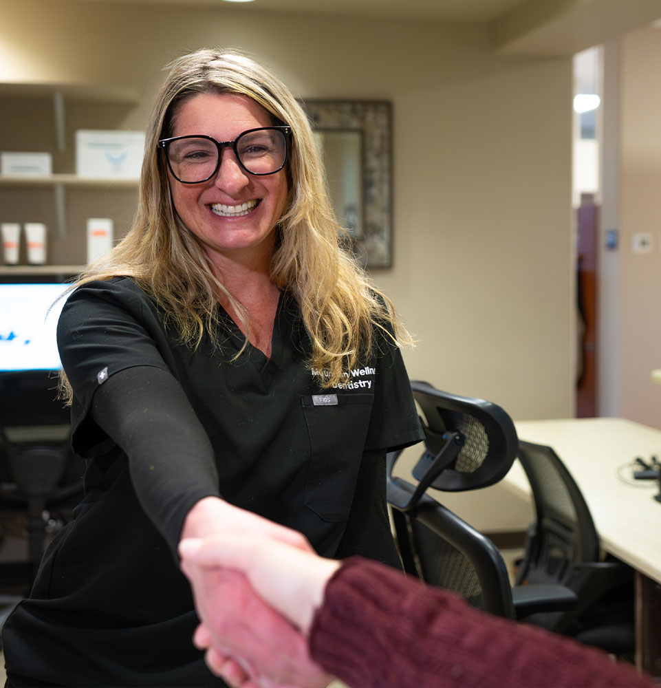 staff member helping patient at the front of the dental center