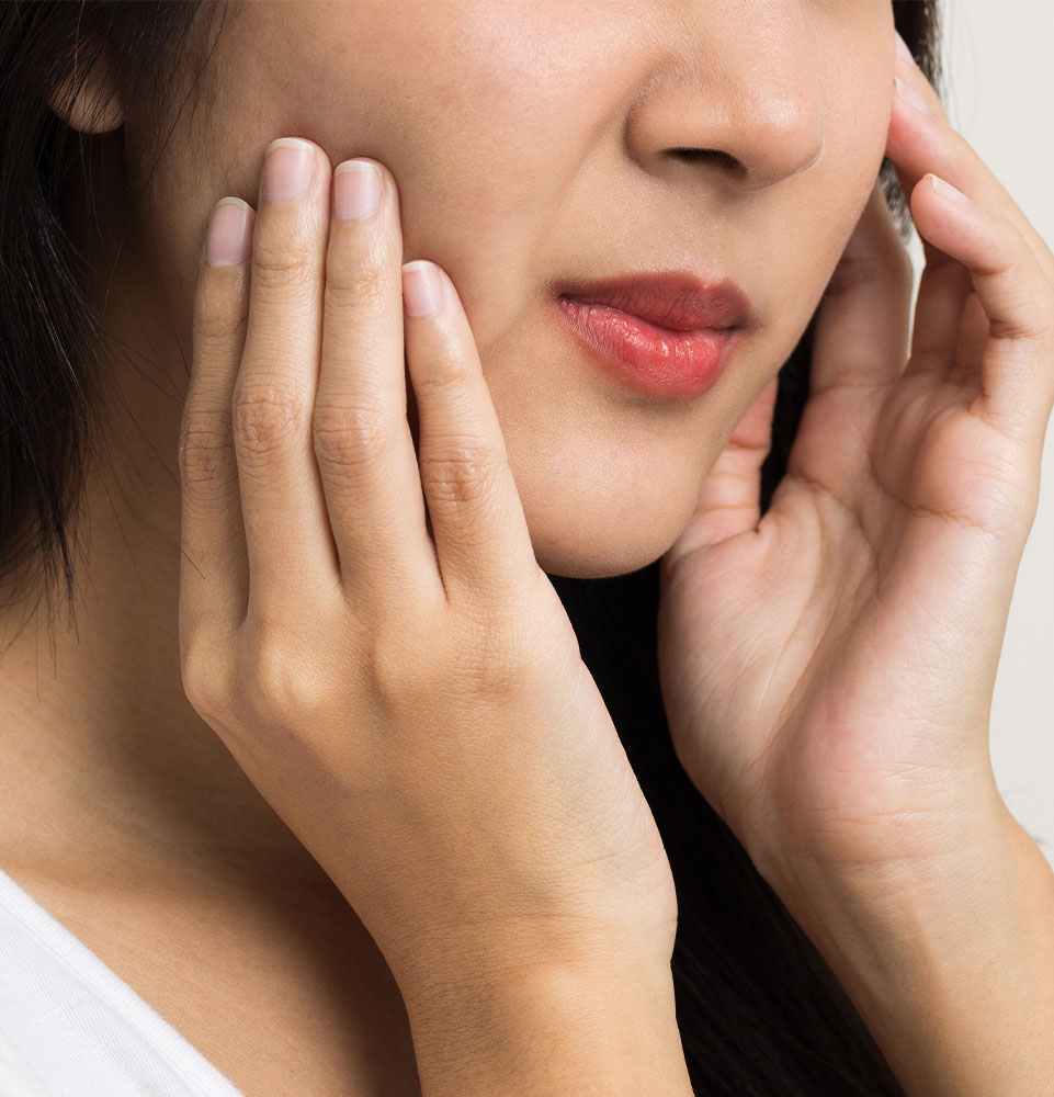 Asian woman puts her hand on her mouth and feels toothache
