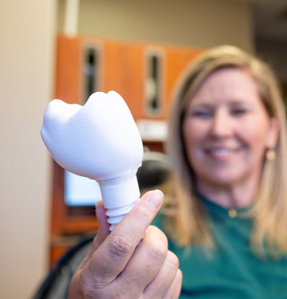 patient looking at giant size dental implant