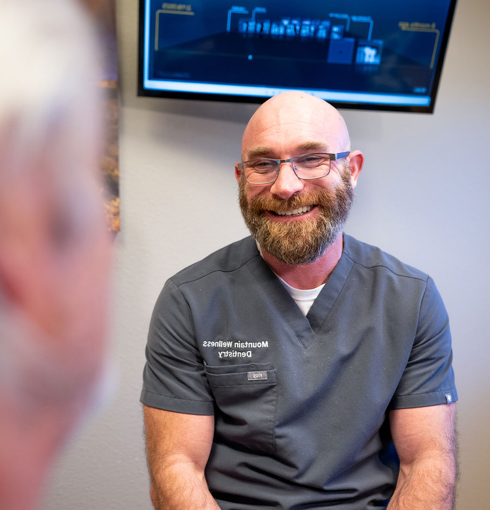 doctor smiling brightly while going over dental procedure information