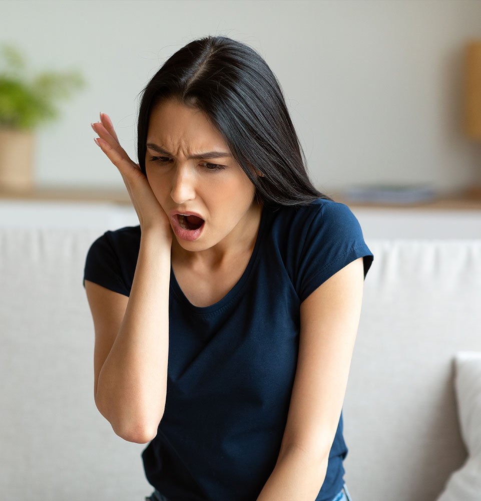 Girl Suffering From Tooth Pain Touching Cheek Sitting At Home