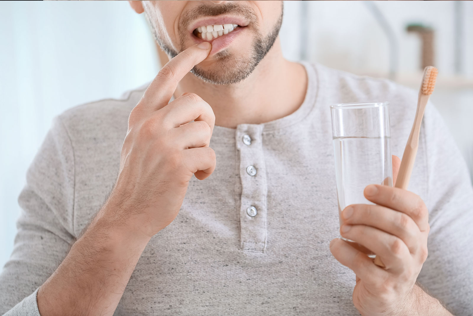 Man suffering from pain while brushing teeth in morning