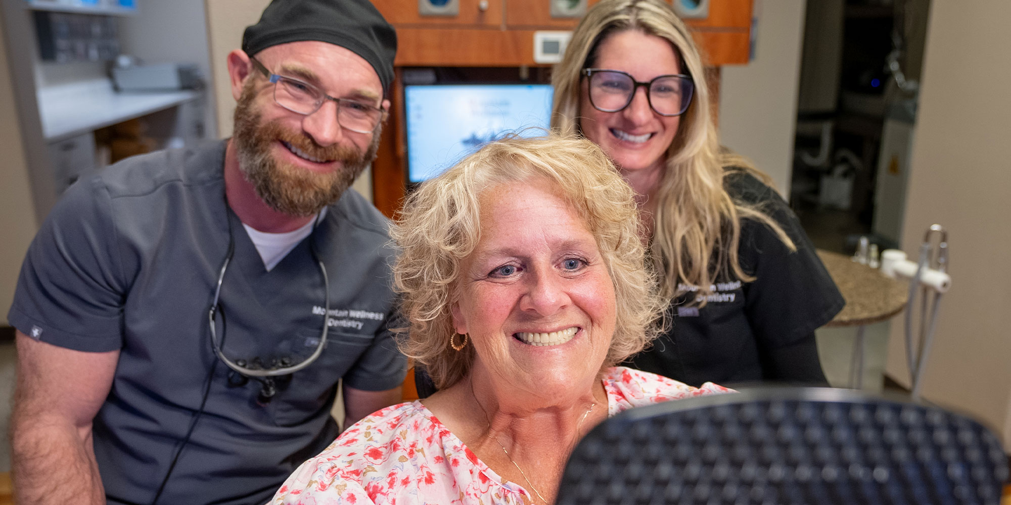 patient and staff member smiling after dental procedure with patient