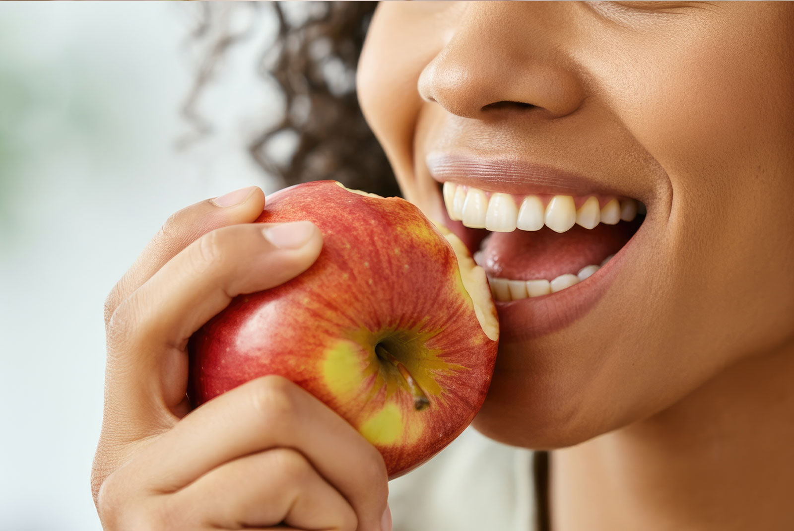 Close-up of woman biting into red apple, promoting healthy eating