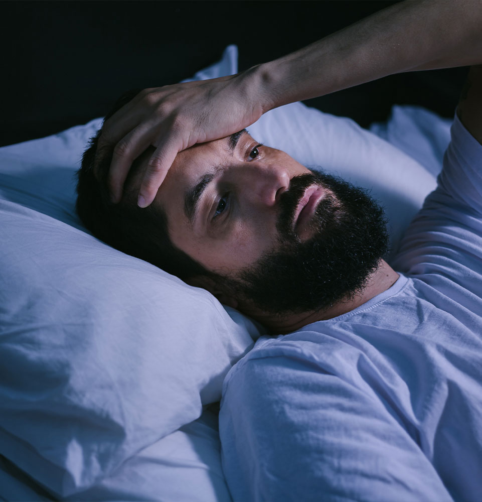 Young man in bed with eyes opened suffering insomnia and sleep disorder