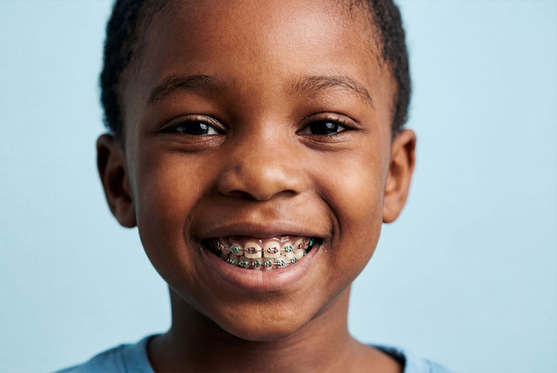 close up of child patient with braces on and smiling